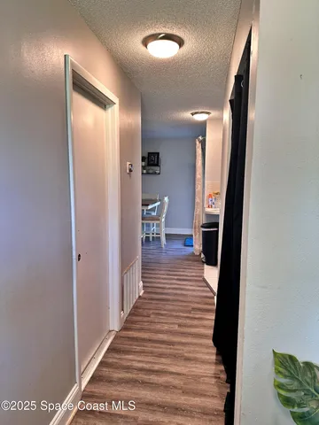 a view of a hallway with wooden floor and staircase