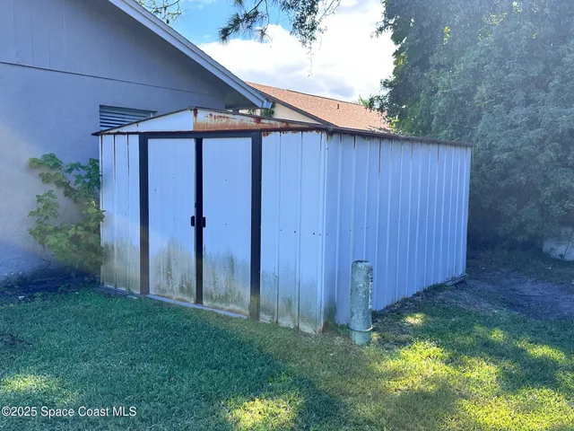 a view of a backyard with potted plants and wooden fence