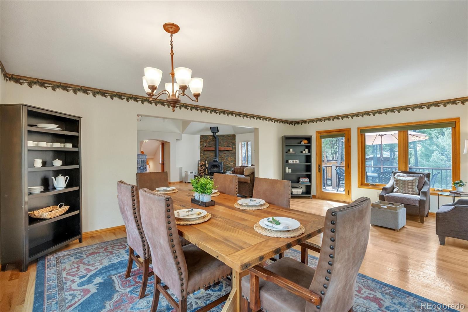 9590 South Warhawk Road Conifer, CO 80433 - Photo 13 of 43 a view of a dining room with furniture wooden floor and chandelier