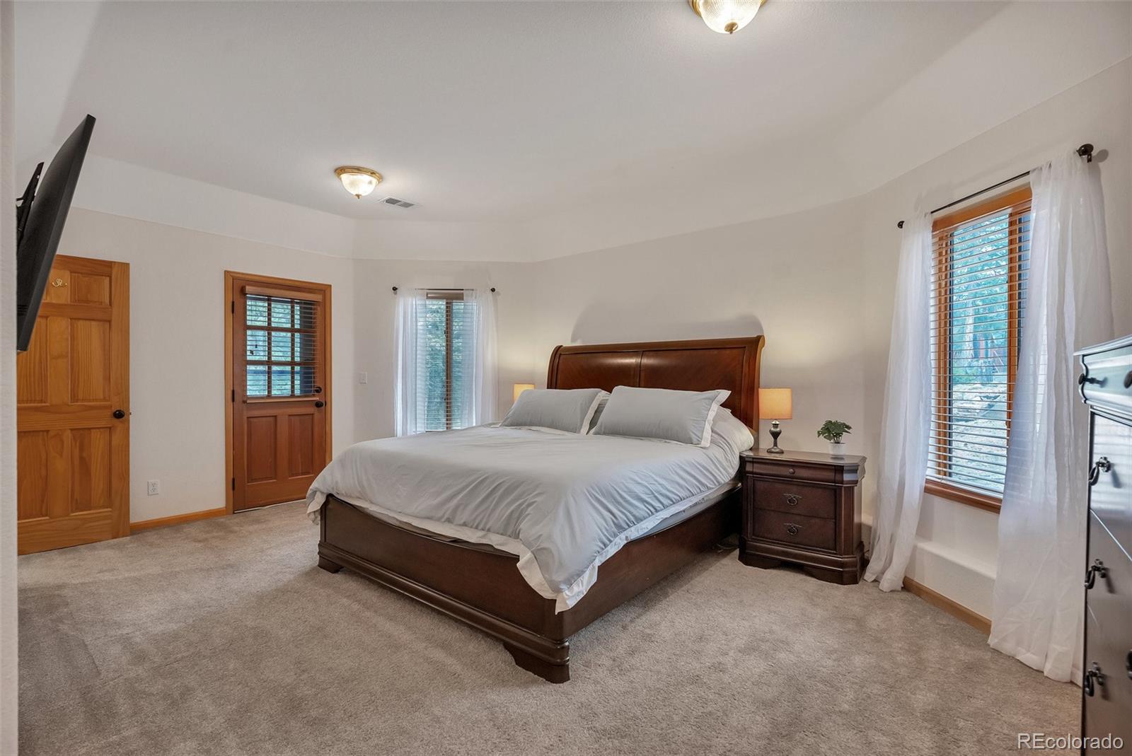 9590 South Warhawk Road Conifer, CO 80433 - Photo 17 of 43 a spacious bedroom with a bed and dresser