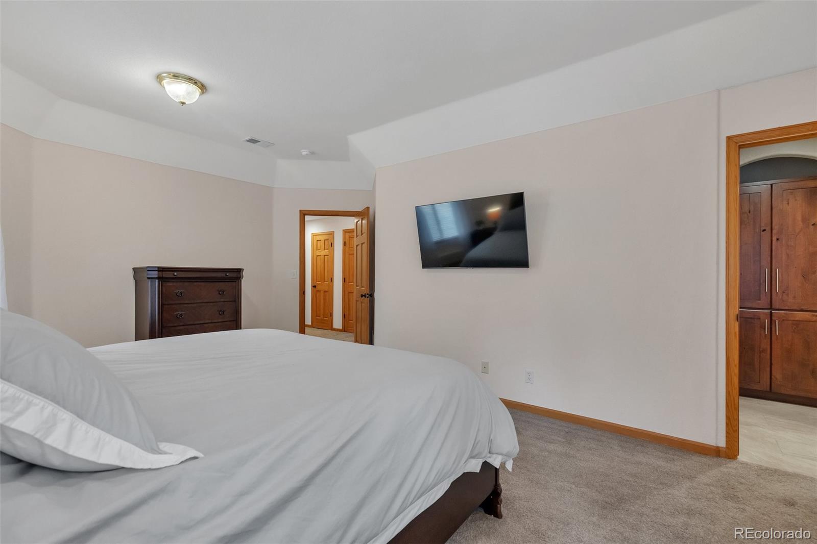 9590 South Warhawk Road Conifer, CO 80433 - Photo 18 of 43 a bedroom with a bed and a flat screen tv