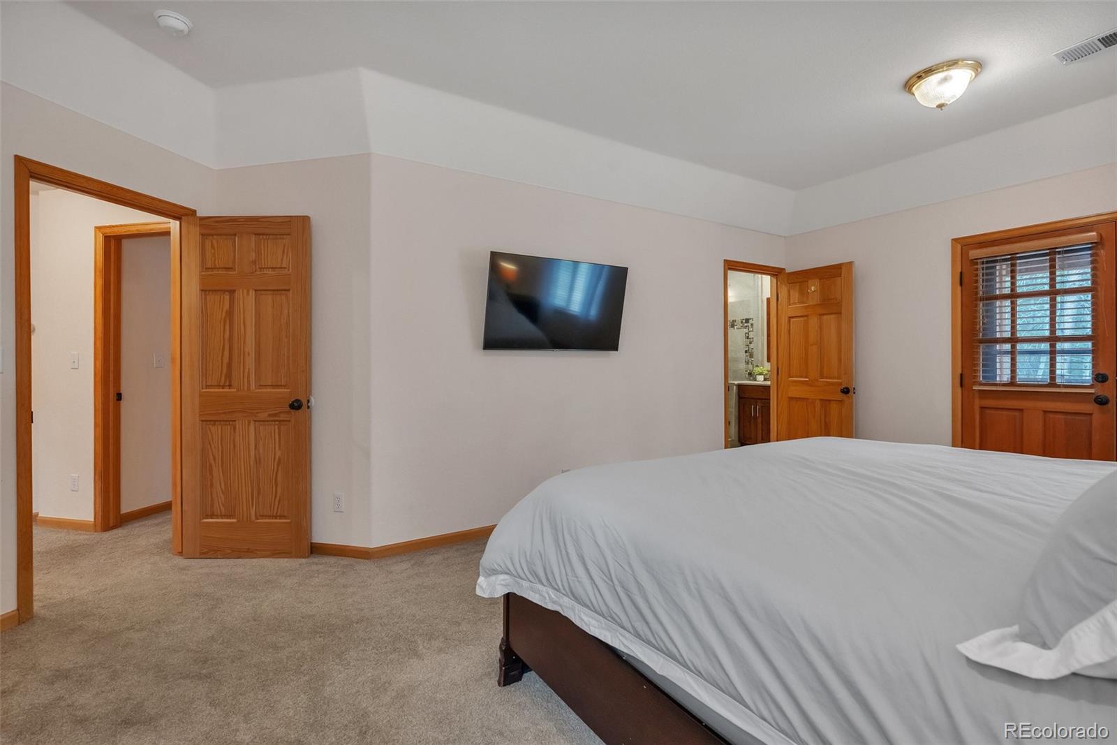 9590 South Warhawk Road Conifer, CO 80433 - Photo 19 of 43 a bedroom with a bed and a flat screen tv