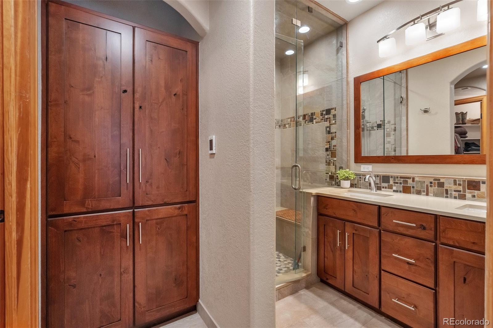 9590 South Warhawk Road Conifer, CO 80433 - Photo 20 of 43 a bathroom with a double vanity sink and a mirror