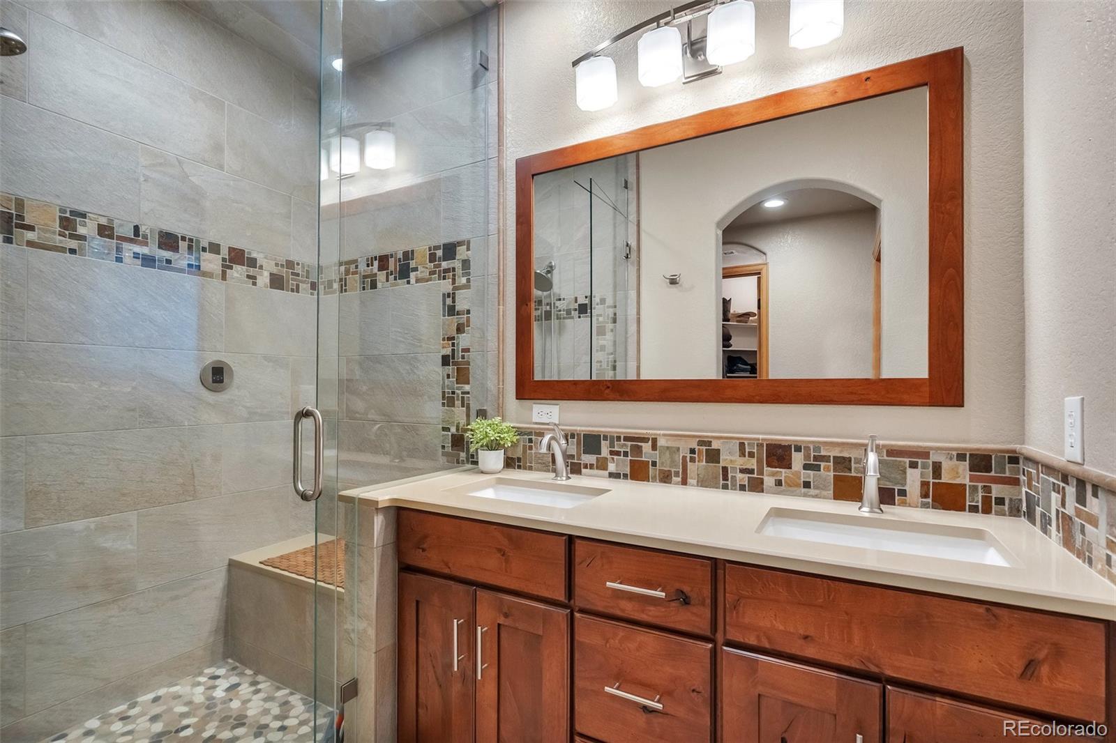9590 South Warhawk Road Conifer, CO 80433 - Photo 21 of 43 a bathroom with a double vanity sink mirror and