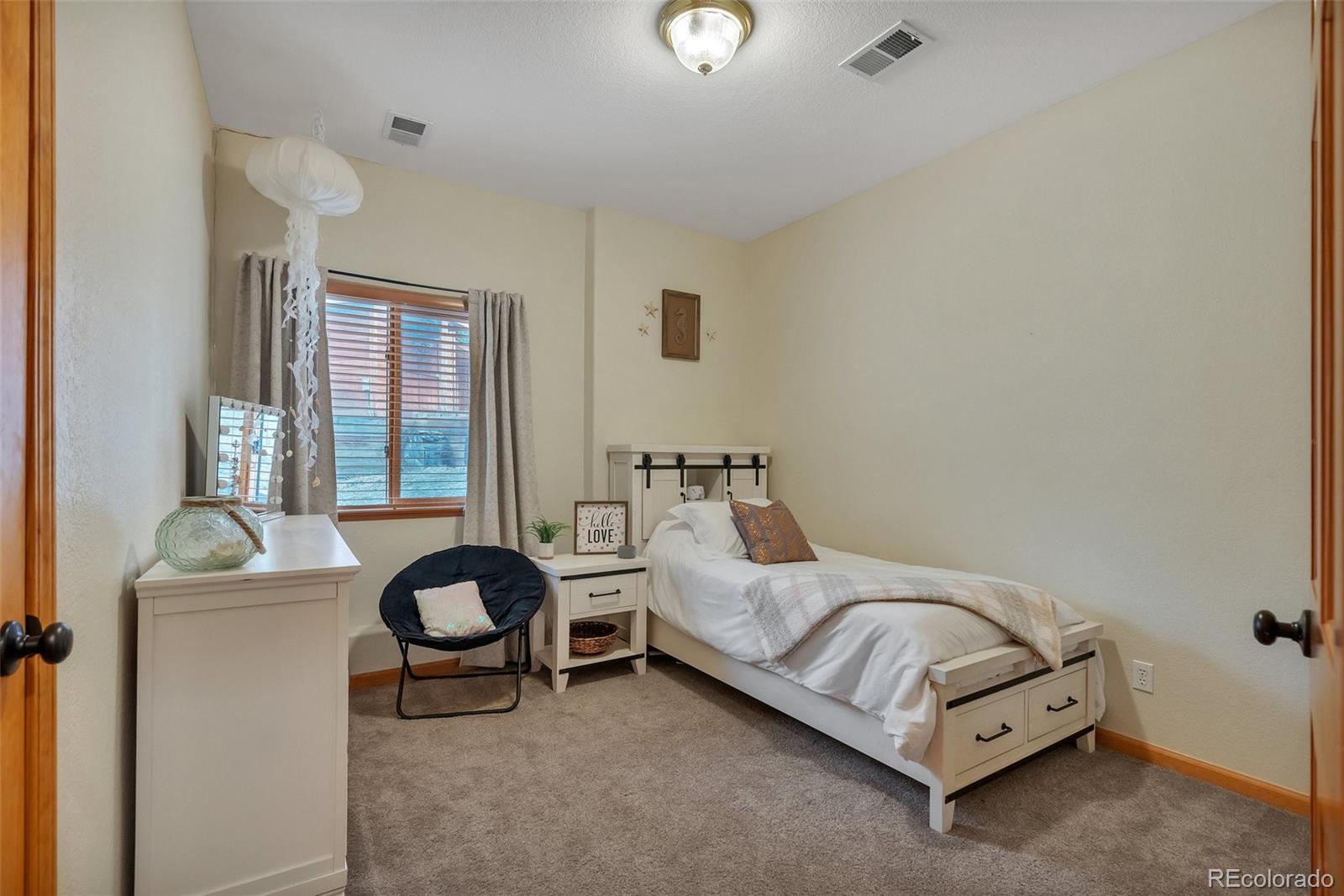 9590 South Warhawk Road Conifer, CO 80433 - Photo 30 of 43 a bedroom with a bed and a table