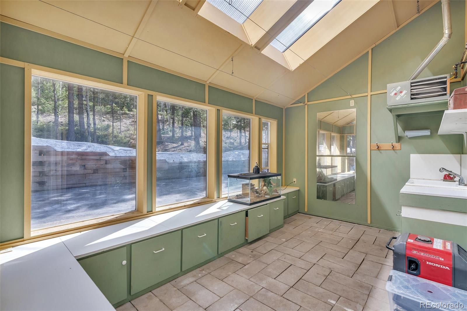 9590 South Warhawk Road Conifer, CO 80433 - Photo 33 of 43 a large bathroom with a sink mirror and a large window