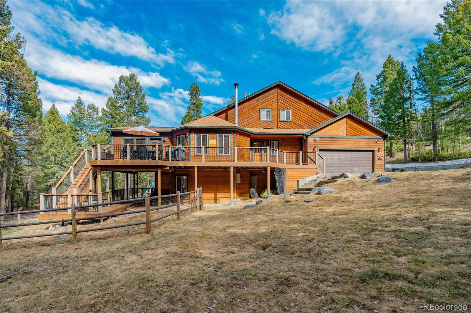 9590 South Warhawk Road Conifer, CO 80433 - Photo 37 of 43 a front view of a house with a yard
