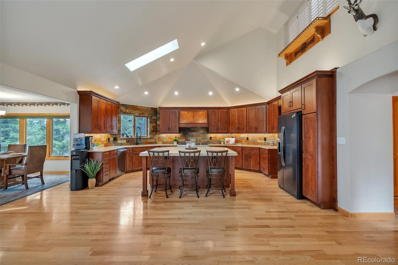 9590 South Warhawk Road Conifer, CO 80433 - Photo 7 of 43 a kitchen with lots of wooden furniture a dining table and chairs