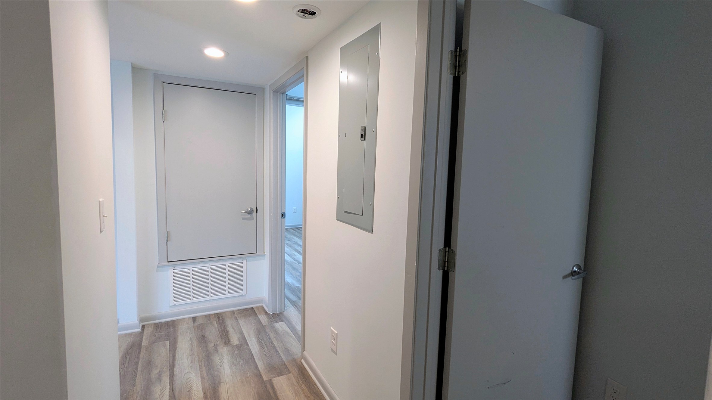 4505 Teri Road, Unit A Austin, TX 78744 - Photo 14 of 23 Clean, light-toned walls and wood-look flooring lead through a well-maintained interior hallway.