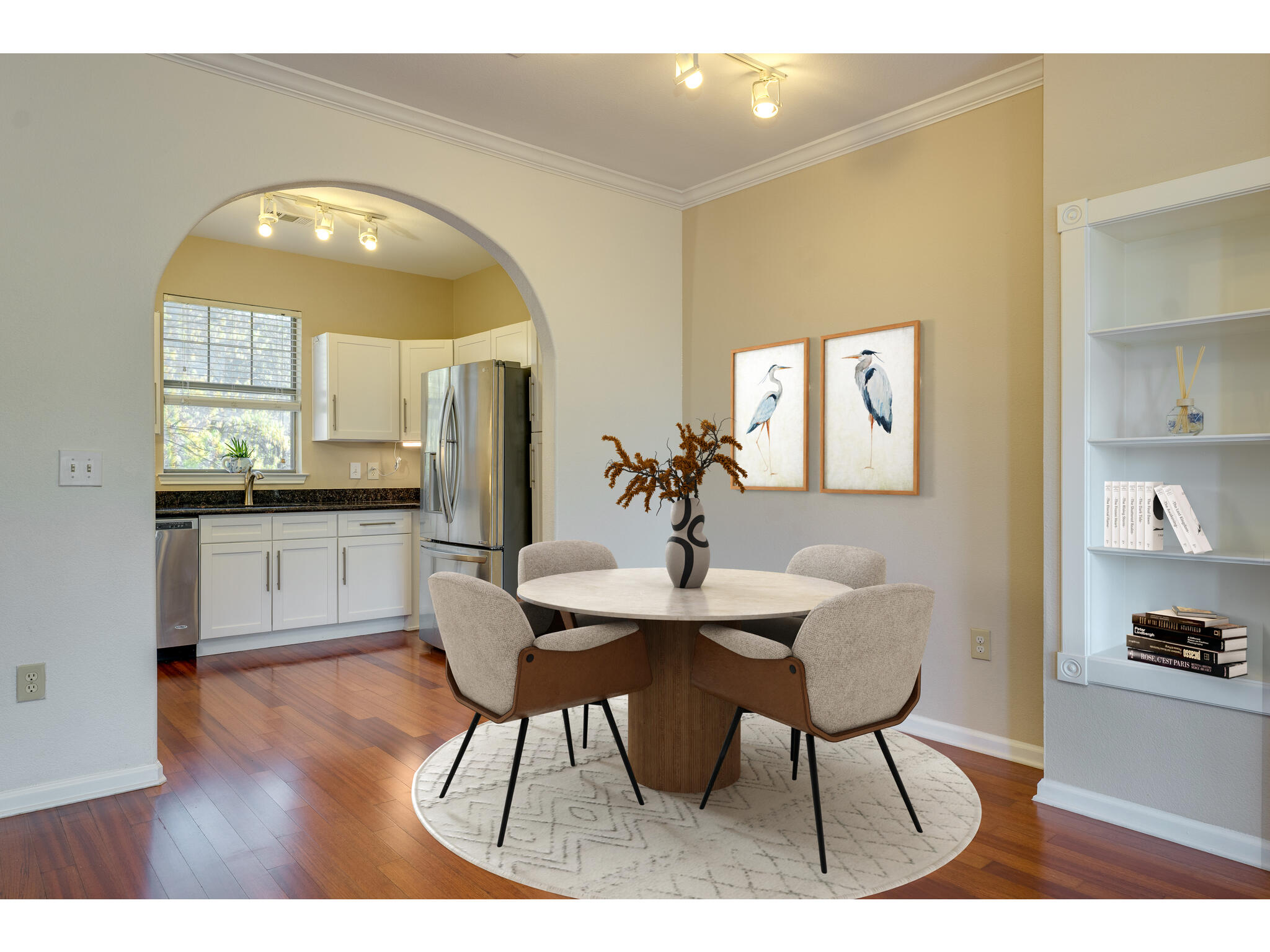11203 Ranch Road 2222, Unit 106 Austin, TX 78732 - Photo 12 of 40 Staged (virtually) dining area featuring crown molding, an arched kitchen entrance, and beautiful wood flooring