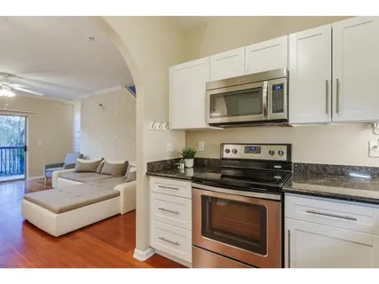 a kitchen with stainless steel appliances granite countertop a stove microwave and cabinets