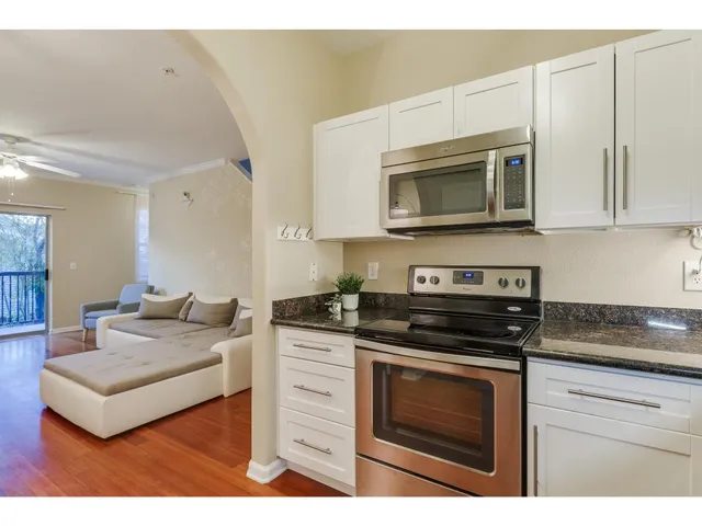 a kitchen with stainless steel appliances granite countertop a stove microwave and cabinets