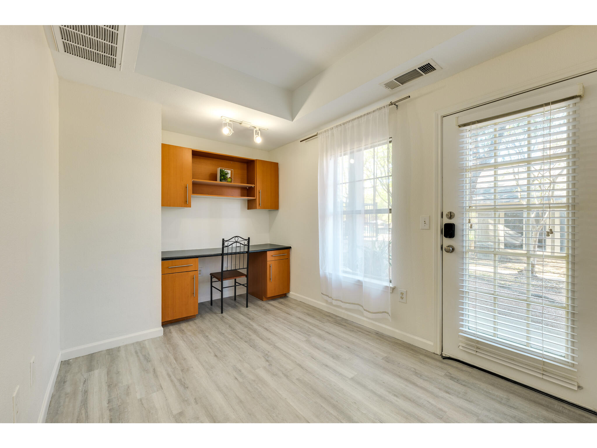 11203 Ranch Road 2222, Unit 106 Austin, TX 78732 - Photo 6 of 40 Office doubling as a second bedroom featuring a built-in desk, LTV floors, and track lighting