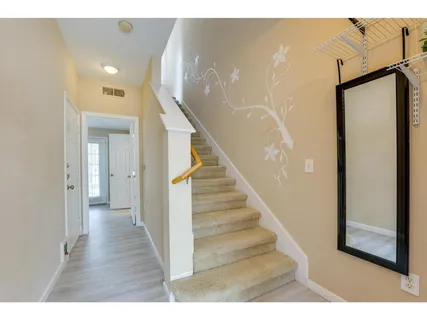 a view of a hallway with wooden floor and staircase