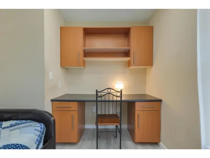 a bedroom with a bed and a lamp on dresser