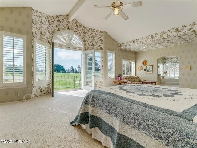 a bed sitting in a spacious bedroom next to a window
