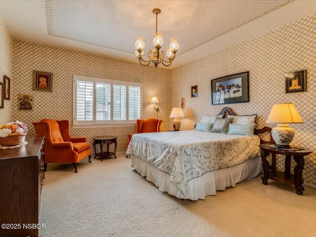 a spacious bedroom with a bed and chandelier