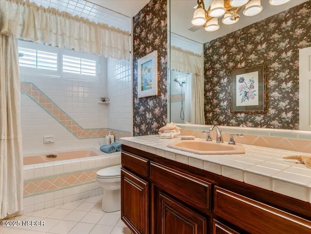 a bathroom with a granite countertop sink a toilet a vanity and bathtub