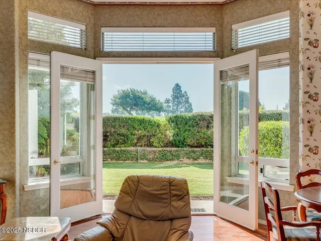 a living room with large glass windows and a table