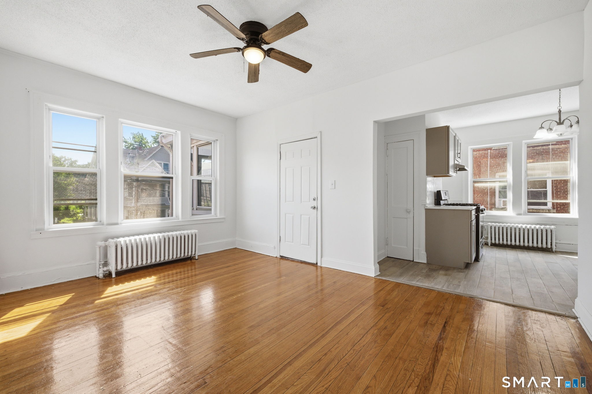115 Baltimore Street, Unit 2 Hartford, CT 06112 - Photo 3 of 14 a view of an empty room with a window and wooden floor