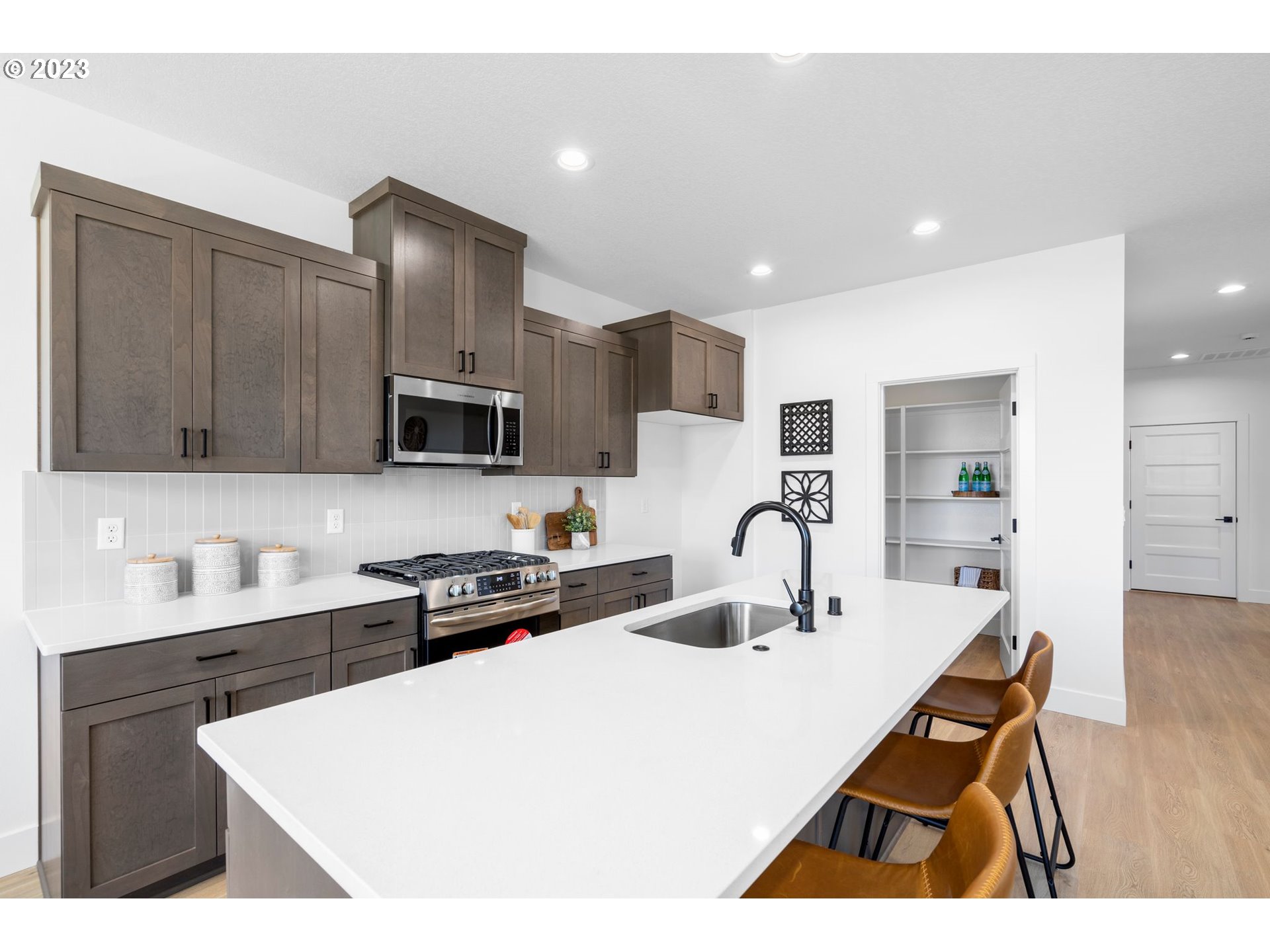 715 Northwest 175th Way Ridgefield, WA 98642 - Photo 5 of 26 a kitchen with stainless steel appliances a sink a stove a refrigerator cabinets and a counter top space