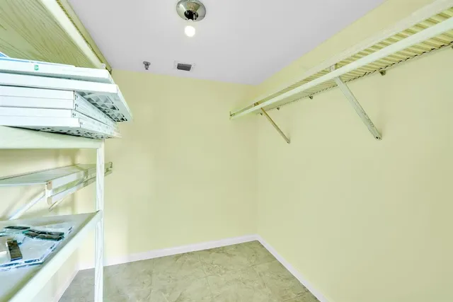 a spacious bedroom with a large bed a flat screen tv and a couch