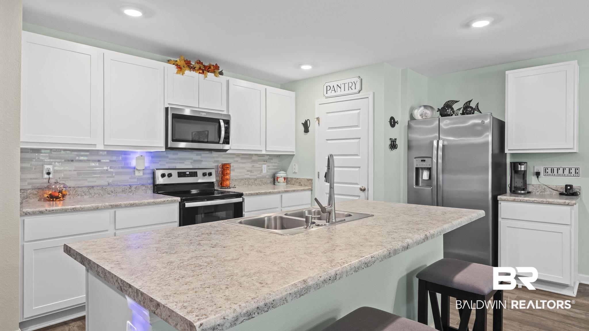 349 Hartenstein Road Foley, AL 36535 - Photo 19 of 32 Kitchen with white cabinets, stainless steel appliances, a breakfast bar, decorative backsplash, and light countertops
