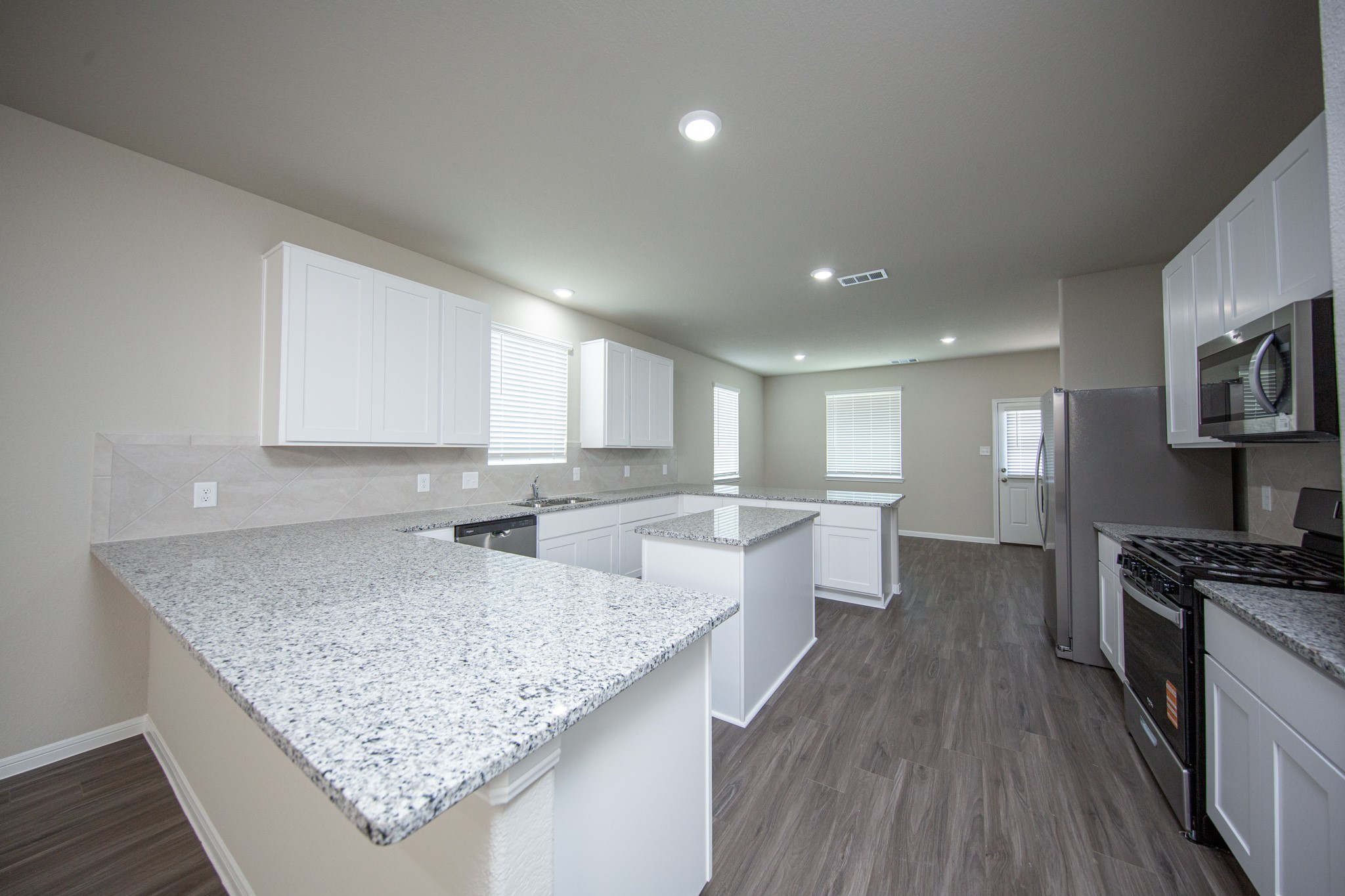 3878 Avalon Lane Conroe, TX 77301 - Photo 6 of 28 a kitchen with stainless steel appliances granite countertop a sink dishwasher stove and oven with wooden floor