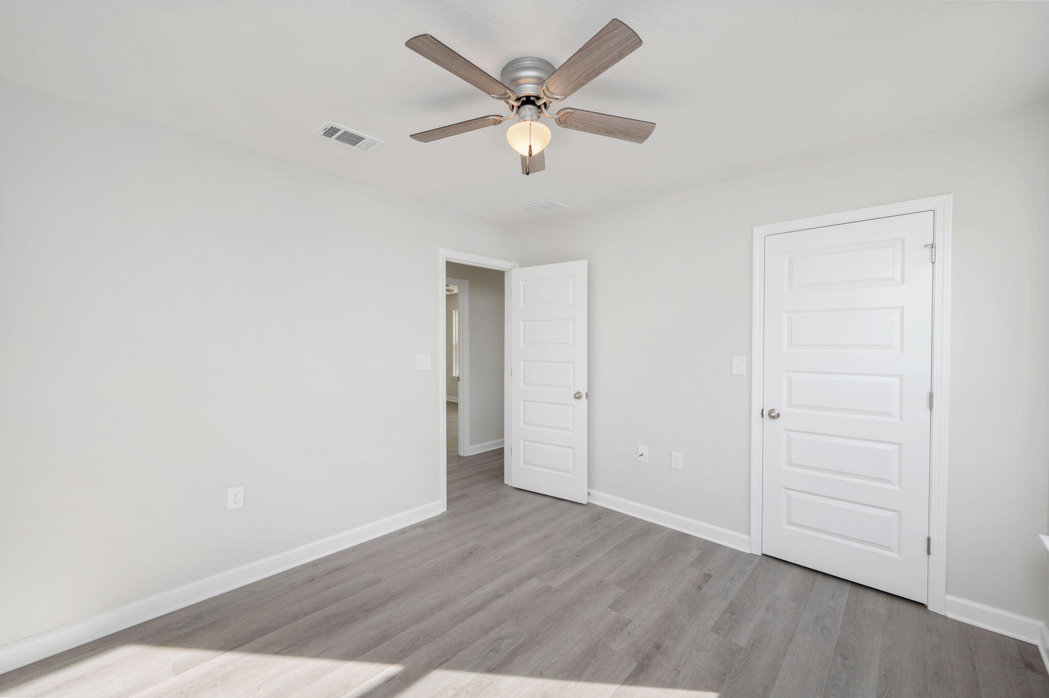 1002 Valley Road Crestview, FL 32539 - Photo 15 of 31 an empty room with wooden floor and ceiling fan