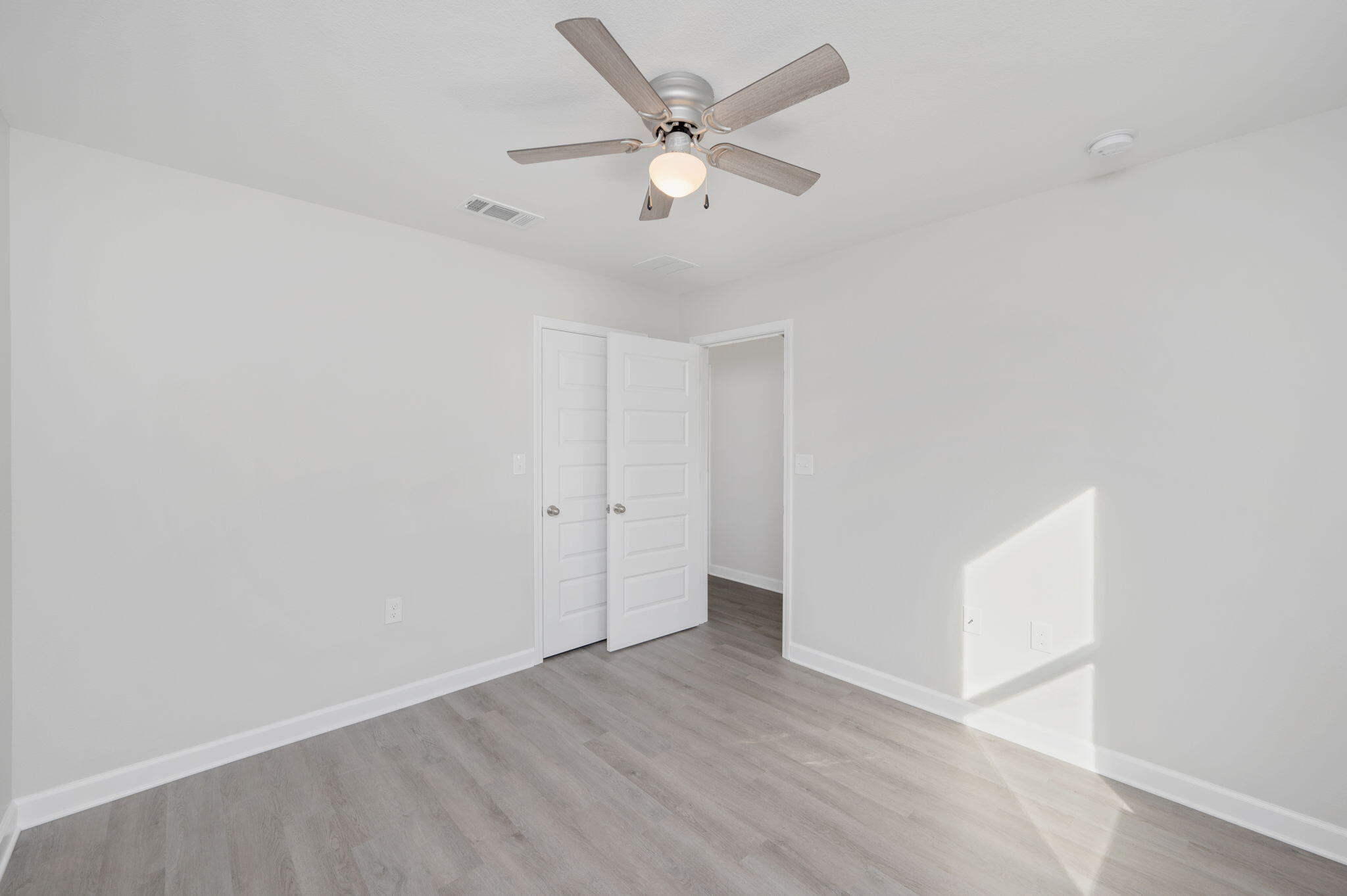 1002 Valley Road Crestview, FL 32539 - Photo 17 of 31 an empty room with wooden floor and ceiling fan