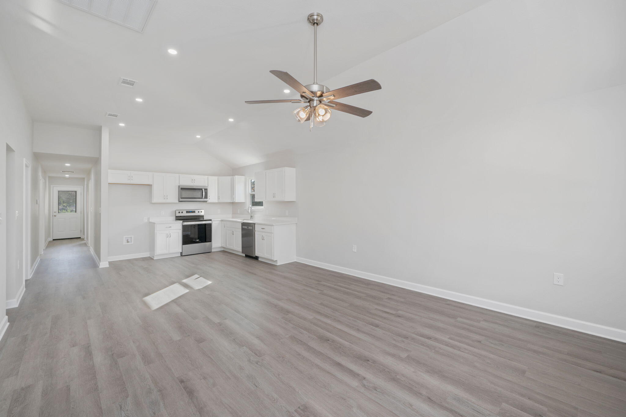 1002 Valley Road Crestview, FL 32539 - Photo 6 of 31 a view of a kitchen with a dishwasher a kitchen island hardwood floor and a ceiling fan