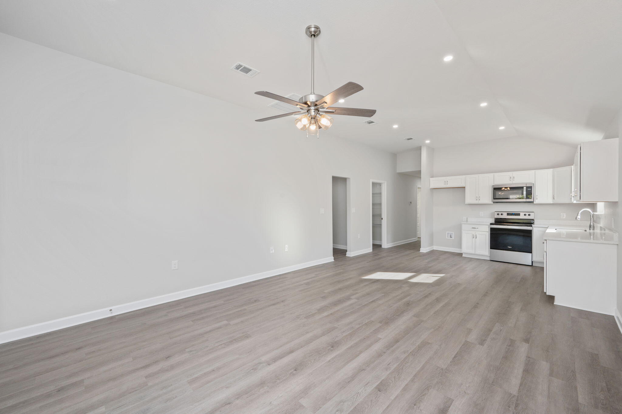 1002 Valley Road Crestview, FL 32539 - Photo 7 of 31 a view of a kitchen with a dishwasher a kitchen island hardwood floor and a ceiling fan