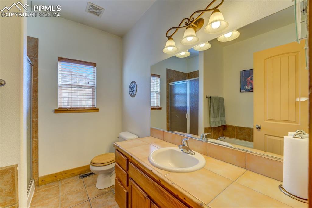 111 Rocchio Drive Florence, CO 81226 - Photo 23 of 50 a bathroom with a granite countertop sink a toilet and mirror