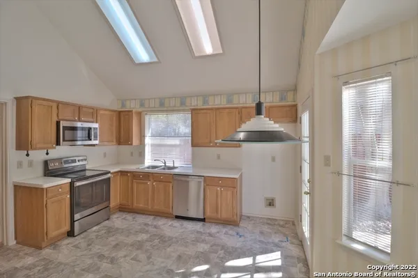 a kitchen with stainless steel appliances granite countertop a sink and a refrigerator