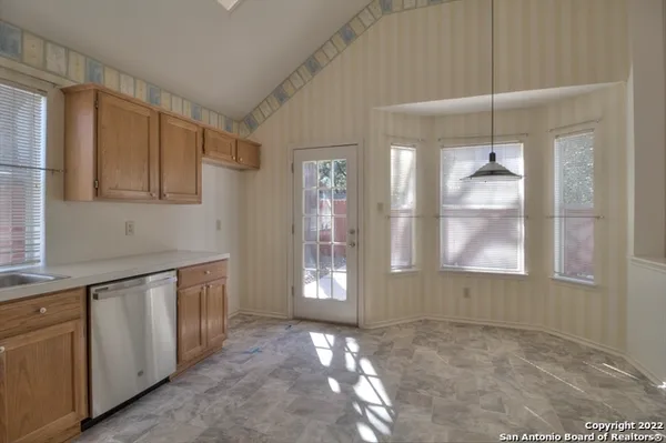 a view of an empty room with window and bathroom