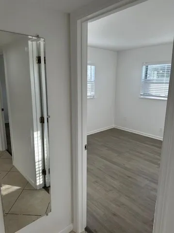 an empty room with wooden floor and a bathroom