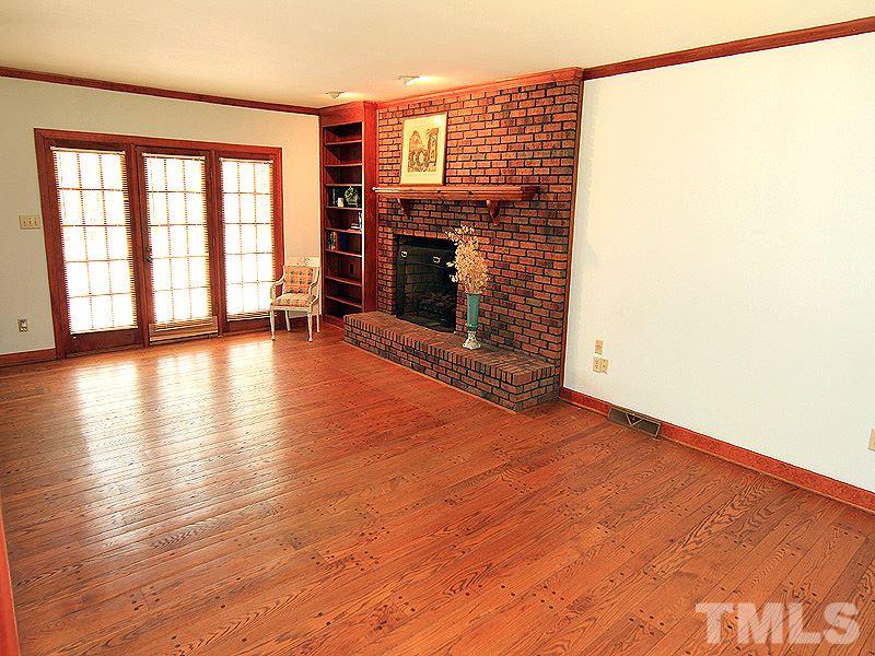 800 Mudham Road Wendell, NC 27591 - Photo 3 of 25 Gas logs in the family room with French doors leading out to the deck and pond.