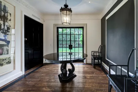 a living room with furniture a flat screen tv and a floor to ceiling window