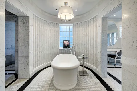 a spacious bathroom with a double vanity sink mirror and bathtub