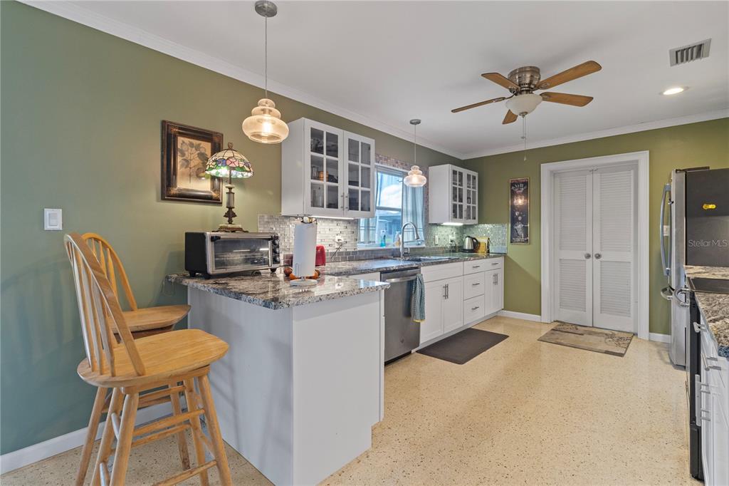 4020 Palm Drive Punta Gorda, FL 33950 - Photo 9 of 24 a kitchen with a table chairs refrigerator and cabinets