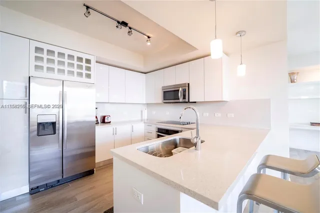 a kitchen with stainless steel appliances a microwave a sink and refrigerator