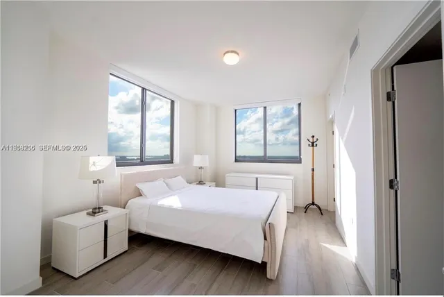 a bedroom with a bed and a large window