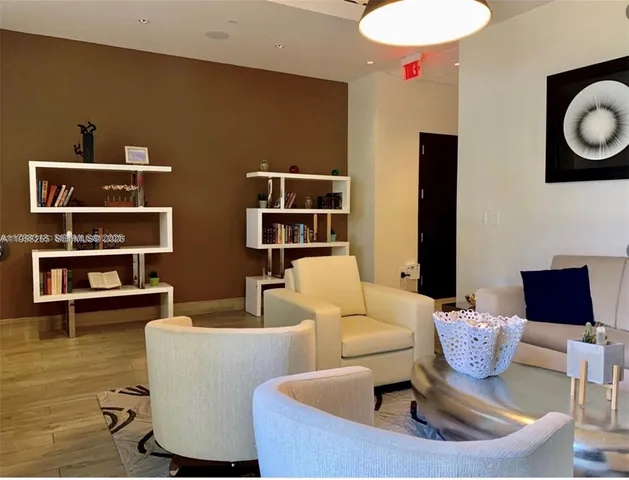 a living room with furniture a rug and white walls
