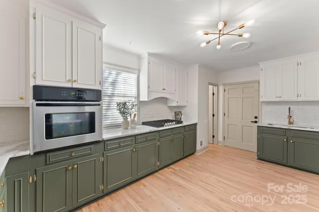 a kitchen with stainless steel appliances granite countertop a sink and cabinets with wooden floor