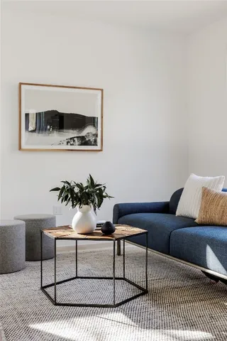a living room with furniture and paintings on the wall