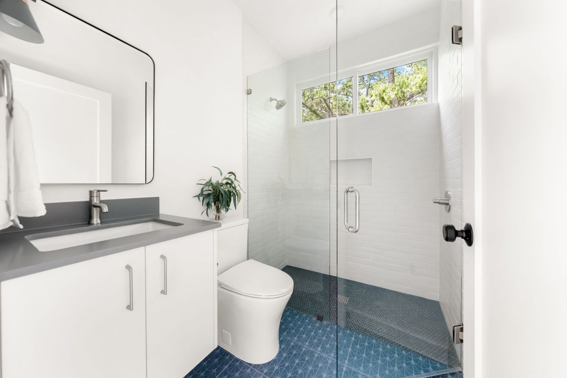 3209 Dolphin Drive, Unit 2 Austin, TX 78704 - Photo 26 of 40 a bathroom with a granite countertop sink a toilet and a mirror