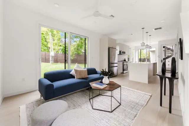 a living room with furniture floor to ceiling window and wooden floor