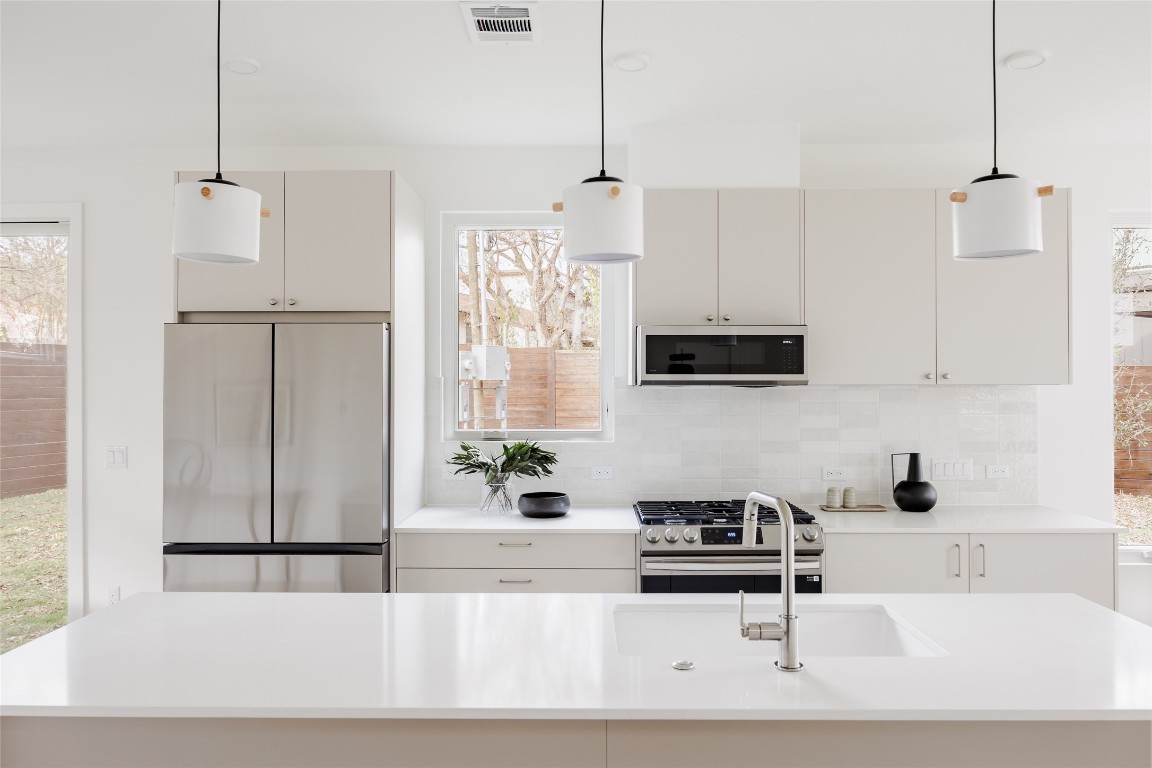 3209 Dolphin Drive, Unit 2 Austin, TX 78704 - Photo 7 of 40 a kitchen with stainless steel appliances granite countertop a sink a stove and a refrigerator