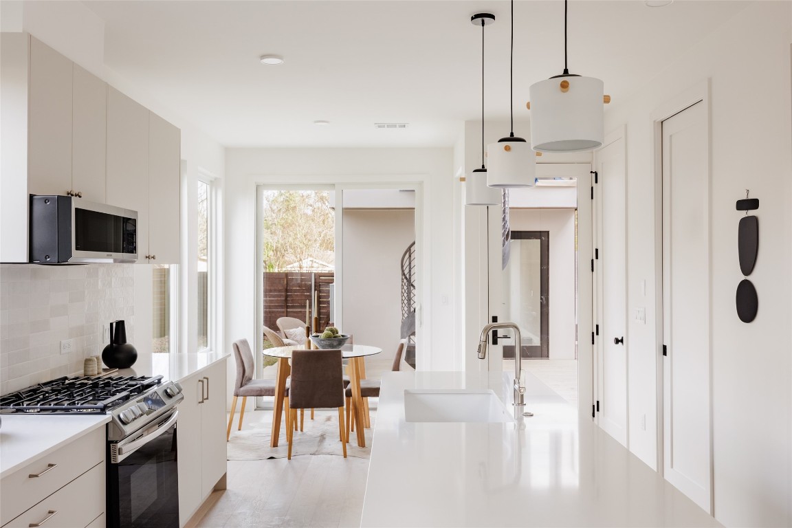 3209 Dolphin Drive, Unit 2 Austin, TX 78704 - Photo 9 of 40 a kitchen with stainless steel appliances kitchen island granite countertop a stove and a refrigerator