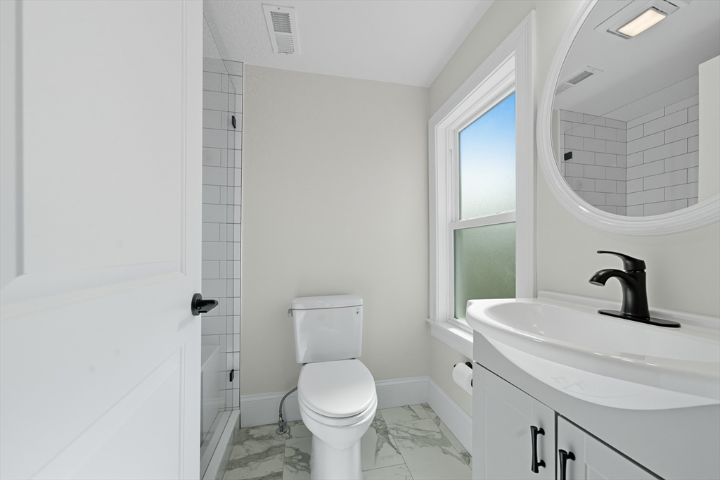 400 Adams Street, Unit A Milton, MA 02186 - Photo 12 of 27 a bathroom with a toilet sink and mirror